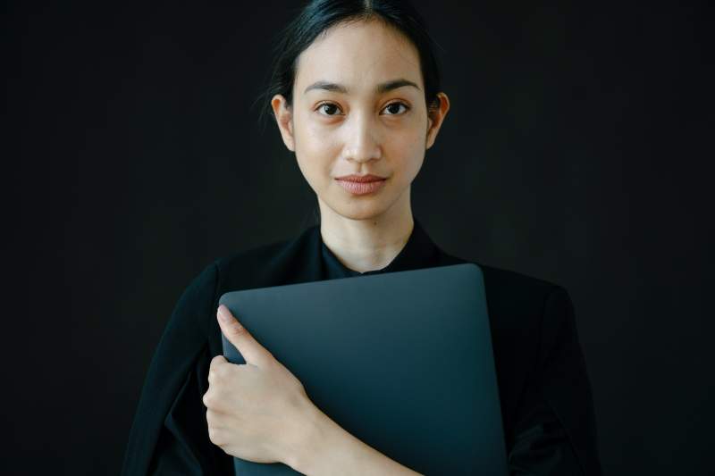 woman-in-black-long-sleeve-shirt-holding-blue-folder